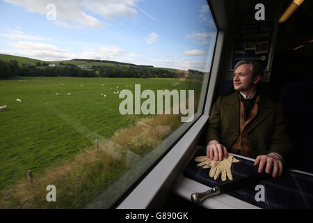 Fergus John McCann come Sir Walter Scott vede la campagna mentre viaggia su un treno ferroviario Borders da Tweedbank a Edimburgo, la più lunga ferrovia nazionale ad aprire nel Regno Unito per più di un secolo, prima dei loro servizi a partire da questo fine settimana. Foto Stock