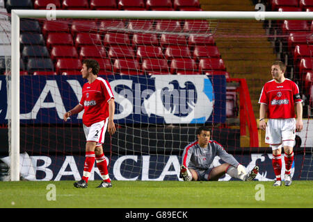 Il portiere atletico di Charlton Darren Randolph si siede espulso dopo aver conceduto un Gol come compagni Lawrie Wilson (l) e Barry Fuller (r) interrogare il linesman Foto Stock