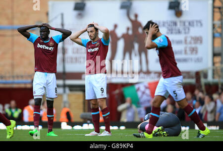 I Cheikhou Kouyate (a sinistra) e Andy Carroll (al centro) di West Ham United appaiono abbattuti durante la partita della Barclays Premier League a Upton Park, Londra. Foto Stock