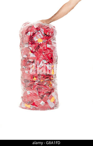 Mano che tiene un trasparente garbage bag piena di rifiuti in plastica Foto Stock
