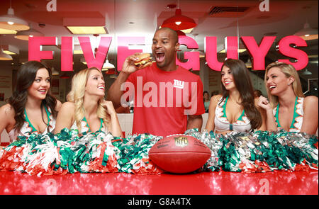 I Miami Dolphin Cheerleaders Etta, Dancia, Britt e Paige e l'Ambasciatore britannico della NFL OSI Umenyiora, vincitore del doppio Super Bowl che recentemente si è ritirato dal gioco, celebrano il lancio della partnership tra NFL e Five Guys presso il ristorante Burger di Covent Garden, Londra. Foto Stock