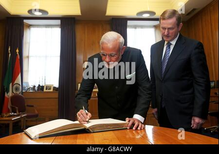 Un Taoiseach Enda Kenny (a destra) con il primo ministro indiano Narendra modi come firma il libro dei visitatori al suo arrivo negli edifici governativi a Dublino, per colloqui di alto livello. Foto Stock