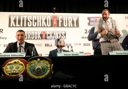 Tyson Fury (a destra) è trattenuto dal padre John come Wladimir Klitschko (a sinistra) guarda avanti durante una conferenza stampa all'Hilton Syon Park, Londra. Foto Stock