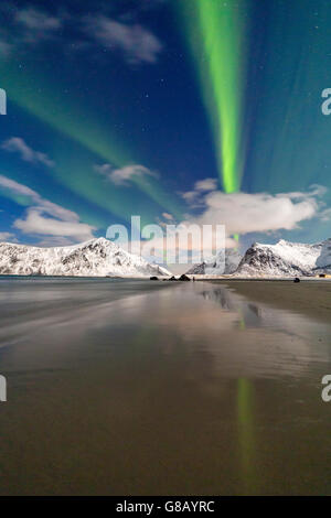 Luci del nord e le montagne si riflette nelle fredde acque Skagsanden Isole Lofoten Norvegia del Nord Europa Foto Stock