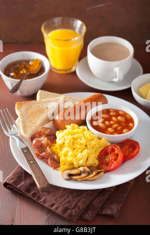 La completa prima colazione inglese con uova strapazzate, pancetta, salsicce, fagioli, pomodori Foto Stock