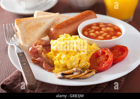 La completa prima colazione inglese con uova strapazzate, pancetta, salsicce, fagioli, pomodori Foto Stock