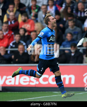 Christian Eriksen di Tottenham Hotspur festeggia il secondo gol della partita da un calcio di punizione durante la partita della Barclays Premier League al Liberty Stadium di Swansea. Foto Stock