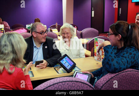 Robert Halfon, deputato per Harlow e Ministro senza portafoglio (centro), entra a far parte della comunità locale Mecca Bingo Club - tre generazioni di famiglia (da sinistra a destra) Lindzee Macaulay, di 61 anni, sua madre Marian McDonald, di 100 anni, E sua nipote Claire Macaulay, di 28 anni, tutti da Epping in Essex, per partecipare a un evento di beneficenza in favore della varietà, la Carità dei Bambini, a Harlow, Essex. Foto Stock