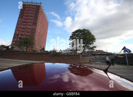 La gente si trova a una fermata dell'autobus sulla Red Road a Glasgow, vicino ai blocchi della Red Road che sono stati lasciati parzialmente in piedi dopo che una demolizione controllata degli appartamenti iconici la domenica non è riuscita a far scendere due di loro. Foto Stock