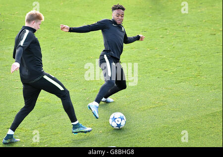 Il Manchester City's Raheem Sterling (a destra) batte per la palla con il Manchester City's Kevin De Bruyne durante una sessione di allenamento presso la City Training Academy di Manchester. Foto Stock