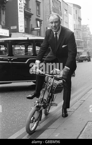 L'ex campione del ciclo sprint mondiale Reg Harris pedala verso il Talk of the Town, Londra, per assistere a una sfilata di moda delle ultime novità in fatto di abbigliamento da bicicletta, organizzata dal British Cycling Bureau. Foto Stock