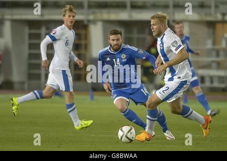 Northerna Ireland Stuart Dallas (centro) in azione contro il finlandese Rasmus Shuller (a sinistra) e Paulus Arajuuri durante la partita di qualificazione del Campionato europeo allo stadio olimpico di Helsinki, Finlandia. Foto Stock