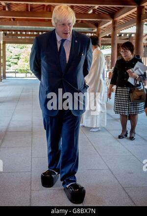 Il Sindaco di Londra Boris Johnson prova con un paio di scarpe da sacerdote in stile aratro al Santuario Meiji Jingu nel centro di Tokyo, il terzo giorno della sua visita commerciale di quattro giorni in Giappone. Foto Stock