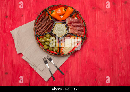 Cestello con tapas spagnoli su un rosso tavolo in legno Foto Stock