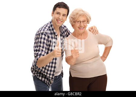Giovane uomo in posa con la nonna ed entrambi dando pollice in alto isolato su sfondo bianco Foto Stock