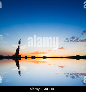 Faro silhouette riflessa nell'acqua Foto Stock