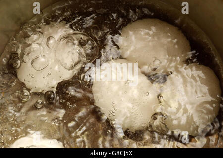 Le uova di gallina in acqua in ebollizione in una pentola di metallo Foto Stock