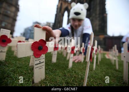 Volontario Ellie le Sueur, 11, della Mary Erskine School inizia a piantare le prime croci nel campo di ricordo di Edinburghs prima dell'apertura di lunedì, Poppyscotland invita il pubblico a piantare croci sul campo durante la settimana di Poppy (da lunedì), in cambio di una donazione, Con l'ambizione di riempire il campo da Armistice Day. Foto Stock