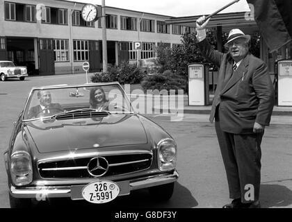 L'ex pilota da corsa Stirling Moss, 36 anni, è stato 'tolto' dal suo vecchio capo, Alfred Neubauer, 75 anni, quando visitò Stoccarda, in Germania, per prendere la sua nuova Mercedes-Benz 230 SL. Nel sedile del passeggero è la moglie Elaine di Stirling Moss. Foto Stock