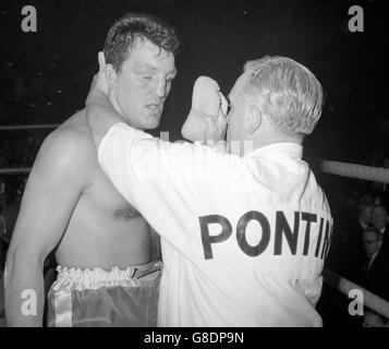 Un abbattuto Brian London (l) ottiene un bastoncino con una spugna dopo il suo knock-out da parte del campione Muhammad Ali nel World Heavyweight Championship alla Earls Court Arena di Londra. Foto Stock