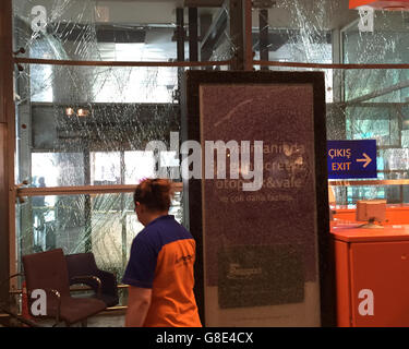 Istanbul, Turchia. Il 29 giugno, 2016. Il personale delle pulizie era in piedi di fronte a frantumi di pannelli di vetro nella sala arrivi dell'Aeroporto Ataturk di Istanbul, in Turchia, 29 giugno 2016. Almeno 36 persone sono state uccise e più di 140 altri sono stati feriti in tre distinti pistola e attentati alla bomba al di fuori e all'interno del terminale di Istanbul è l'aeroporto internazionale Ataturk il 28 giugno, media riportati citando funzionari. Foto: Mirjam Schmitt/dpa/Alamy Live News Foto Stock