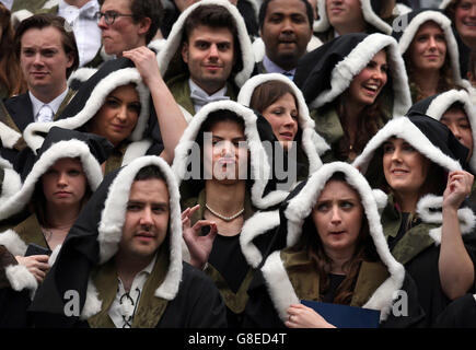 Università di Edimburgo gli studenti riparo dalla pioggia come hanno fotografie ufficiali presi dopo la loro cerimonia di laurea alla Usher Hall di Edimburgo. Foto Stock