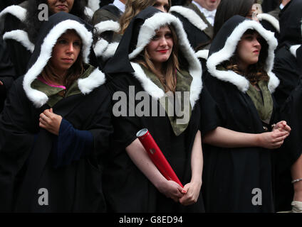 Università di Edimburgo gli studenti riparo dalla pioggia come hanno fotografie ufficiali presi dopo la loro cerimonia di laurea alla Usher Hall di Edimburgo. Foto Stock