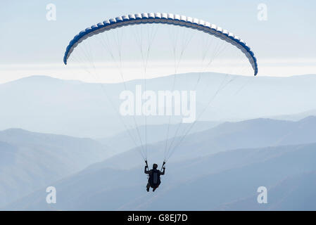 Il parapendio vola nel morbido cielo blu. Foto Stock