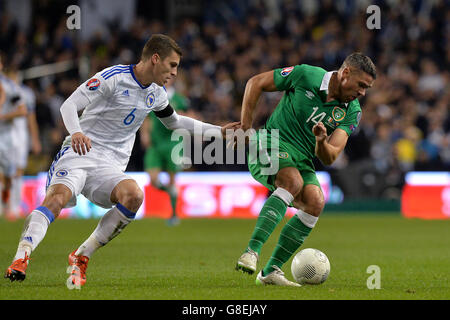 Jonathan Walters (a destra) della Repubblica d'Irlanda e Ognjen Vranjes (a sinistra) della Bosnia-Erzegovina combattono per la palla durante la seconda tappa di qualificazione UEFA Euro 2016 allo stadio Aviva di Dublino. Foto Stock