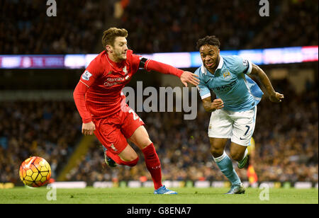 Raheem Sterling (a destra) di Manchester City e Adam Lallana di Liverpool combattono contro il pallone durante la partita della Barclays Premier League all'Etihad Stadium di Manchester. Foto Stock