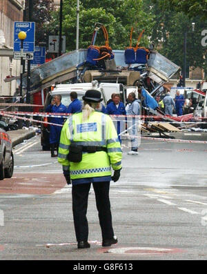 Un ufficiale della Comunità di polizia di Suport esamina i danni di un'esplosione di autobus in piazza Tavistock. Le esplosioni oggi sono scoppiate nel centro di Londra, con decine di morti temute e la città precipitata nel caos. Foto Stock