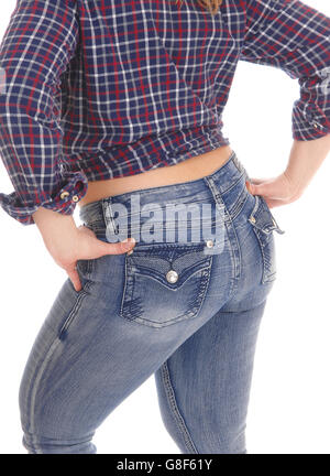 Un Medioevo donna in jeans e una camicia a scacchi in piedi dal retro che mostra il suo bel fondo, isolato per sfondo bianco. Foto Stock