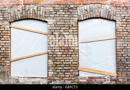 Le finestre chiuse su weathered muro di mattoni - ristrutturazione Foto Stock