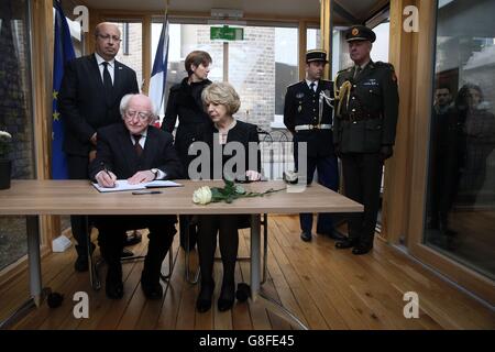 Il presidente irlandese Michael D Higgins e sua moglie Sabina firmano un libro di condoglianze in compagnia dell'ambasciatore francese e della moglie Aurore all'ambasciata francese di Dublino, dopo un minuto di silenzio in tutta Europa per celebrare le vittime degli attacchi del venerdì nella capitale francese. Foto Stock