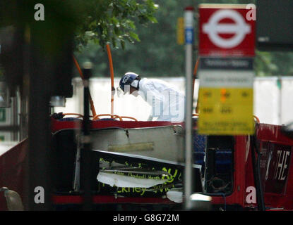 Un ufficiale di polizia si trova su quello che rimane del ponte superiore dell'autobus numero 30, che è stato fatto esplodere da una bomba nella serie di attentati terroristici nel centro di Londra giovedì scorso mattina. Foto Stock