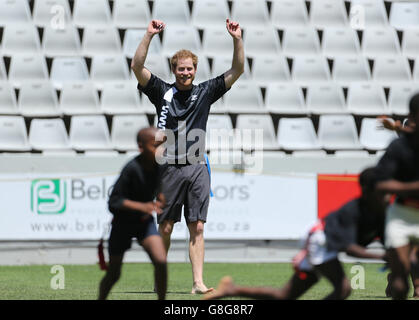 Il principe Harry gioca a tag rugby con i bambini al Kings Park Stadium mentre si unisce ai membri della squadra di rugby Sharks sul campo a Durban, in una sessione di addestramento e di abilità con allenatori e giovani giocatori come parte della sua visita in Sud Africa. Foto Stock