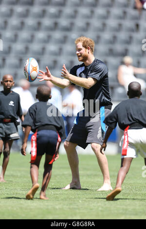 Il principe Harry gioca a tag rugby con i bambini al Kings Park Stadium mentre si unisce ai membri della squadra di rugby Sharks sul campo a Durban, in una sessione di addestramento e di abilità con allenatori e giovani giocatori come parte della sua visita in Sud Africa. Foto Stock