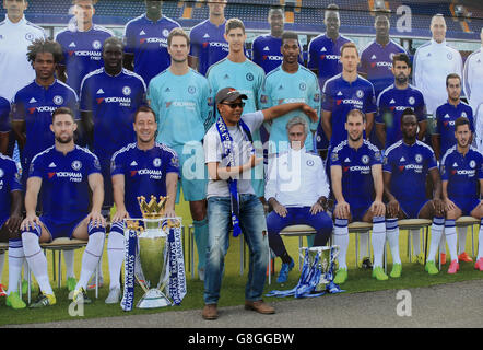 Un fan del Chelsea si pone per una foto fuori terra davanti a un'immagine gigante della squadra, tra cui l'ex manager Jose Mourinho, prima della partita della Barclays Premier League a Stamford Bridge, Londra. Foto Stock