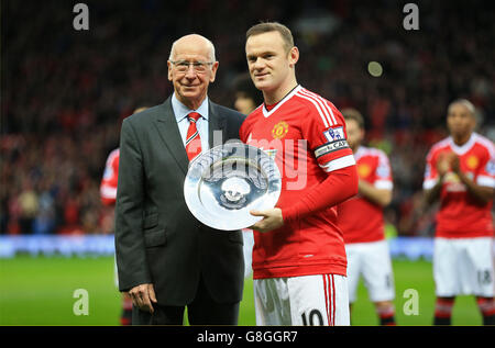 Sir Bobby Charlton presenta Wayne Rooney di Manchester United con un trofeo che segna la sua 500° apparizione per il club prima della partita Barclays Premier League a Old Trafford, Manchester. Foto Stock