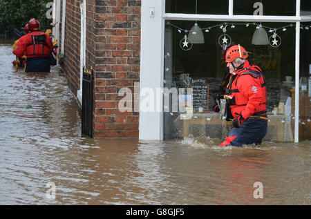 I membri delle squadre di soccorso della montagna guardano alle proprietà allagate in Tower Street, York. Foto Stock