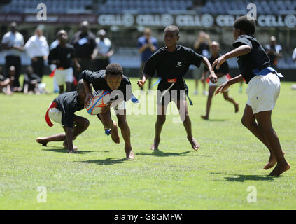 Il principe Harry gioca a tag rugby con i bambini al Kings Park Stadium mentre si unisce ai membri della squadra di rugby Sharks sul campo a Durban, in una sessione di addestramento e di abilità con allenatori e giovani giocatori come parte della sua visita in Sud Africa. Foto Stock