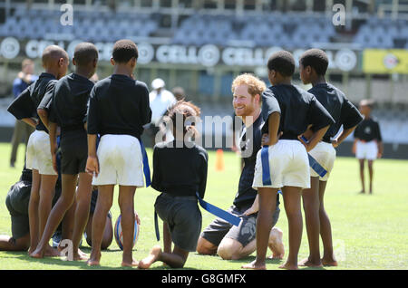 Il principe Harry gioca a tag rugby con i bambini al Kings Park Stadium mentre si unisce ai membri della squadra di rugby Sharks sul campo a Durban, in una sessione di addestramento e di abilità con allenatori e giovani giocatori come parte della sua visita in Sud Africa. Foto Stock