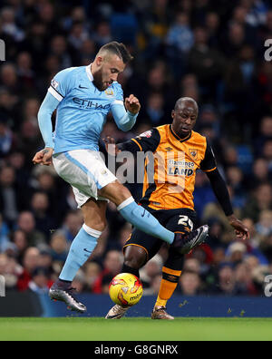 Nicolas Otamendi di Manchester City (a sinistra) e Sone Aluko di Hull City combattono per la palla durante la Capital One Cup, Quarter Final all'Etihad Stadium di Manchester. Foto Stock