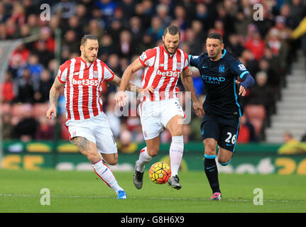 Marko Arnautovic di Stoke City (a sinistra) ed Erik Pieters (al centro) combattono per la palla contro Martin Demichelis di Manchester City (a destra). Foto Stock