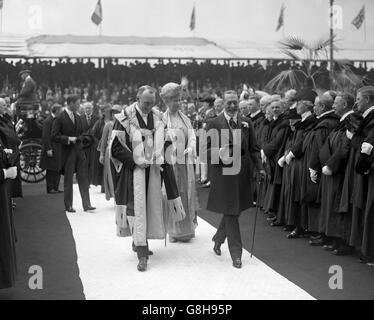 Re Giorgio V e la regina Maria sono accompagnati dal Lord Provost Sir Thomas Hutchinson, mentre hanno aperto la nuova centrale elettrica a Portobello. I membri della City Corporation sono allineati su entrambi i lati. Foto Stock