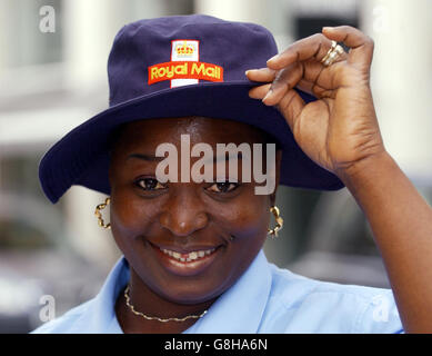 La postdonna di legno di St John Tayo Falowo, indossa il nuovo cappello estivo per i lavoratori postali mentre si trova a Londra. Migliaia di addetti alle poste avranno un inizio di battaglia per tenere il sole fuori dagli occhi sui turni di consegna con l'introduzione di un nuovo cappello. I cappelli larghi e di colore blu assomigliano a quelli indossati dai cricketers. Foto Stock