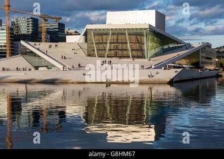 Teatro dell'Opera di Oslo si riflette nella baia al tramonto Foto Stock