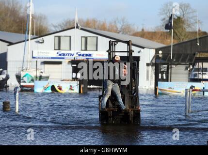 I proprietari di aziende utilizzano un carrello elevatore a forche per attraversare le acque alluvionali a Kinnago Marina, vicino a Dungannon, che è influenzato dall'aumento dei livelli d'acqua a Lough Neagh. Foto Stock