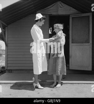 Infermiere residente in visita a un bambino malato, Farm Security Administration (FSA) Camp, Farmersville, Tulare County, California, USA, Dorothea Lange per la Farm Security Administration, Maggio 1939 Foto Stock