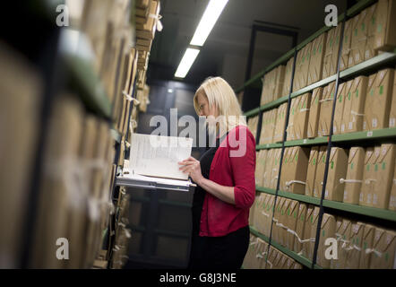 22/12/15 un membro del personale nei repositori dell'Archivio Nazionale di Kew, come un certo numero di documenti che risalgono agli anni '80 sono stati rilasciati. Foto Stock